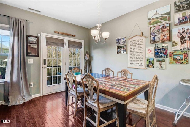 dining room featuring dark wood-style floors, an inviting chandelier, visible vents, and baseboards