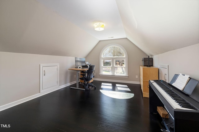 interior space featuring dark wood-type flooring, lofted ceiling, visible vents, and baseboards