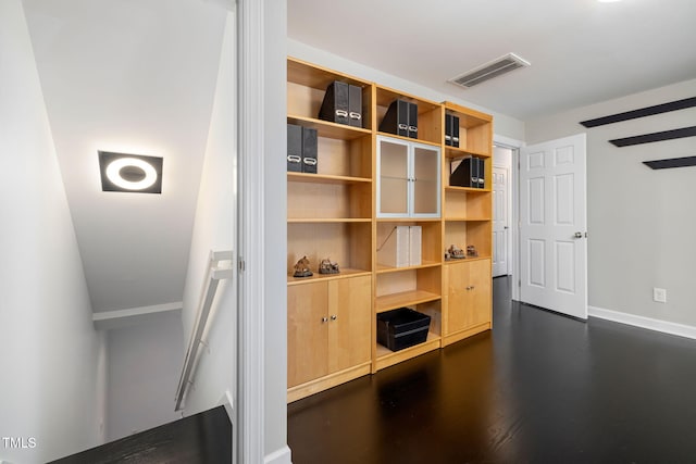 interior space with baseboards, visible vents, and wood finished floors