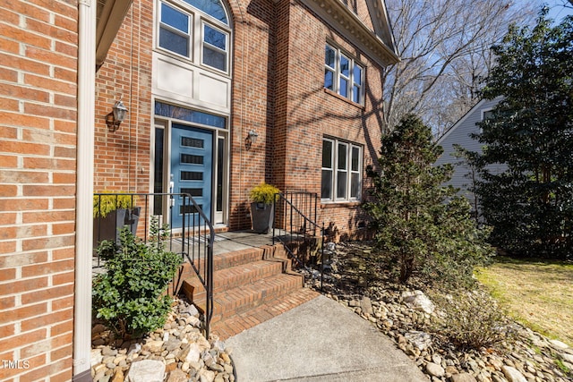 entrance to property featuring brick siding