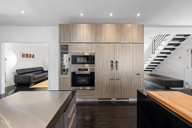 kitchen with stainless steel appliances, dark wood-type flooring, modern cabinets, and recessed lighting