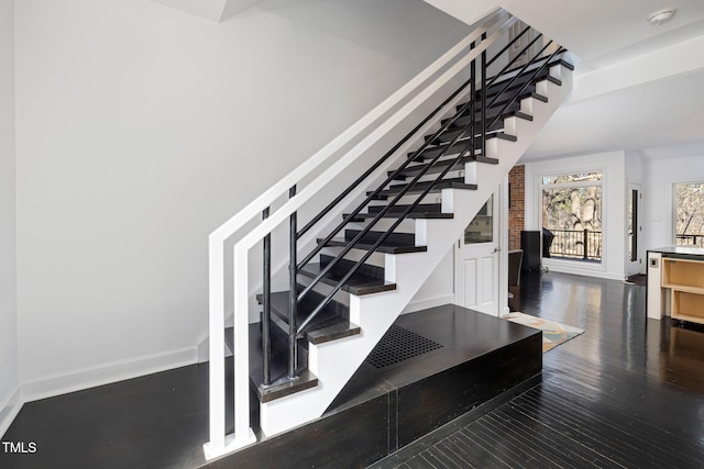 staircase featuring baseboards and wood finished floors