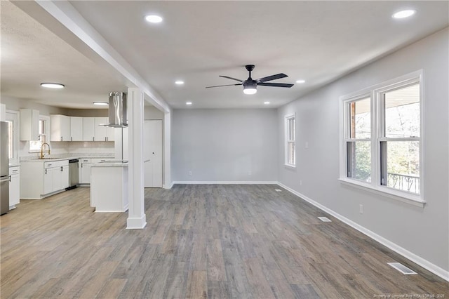 unfurnished living room featuring baseboards, wood finished floors, and recessed lighting