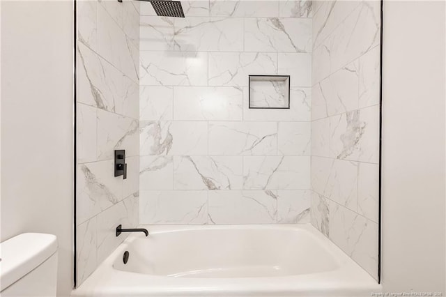 bathroom featuring shower / washtub combination and toilet