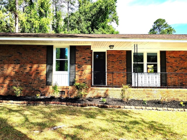 1612 Rogers Dr, Fayetteville, NC 28303 - property entrance featuring a yard, brick siding, and a porch
