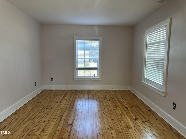 unfurnished room featuring light wood finished floors and baseboards