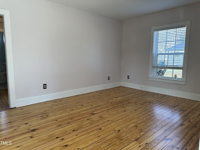 unfurnished room with light wood-style flooring and baseboards