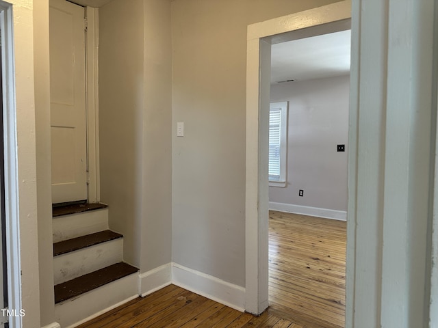 staircase featuring baseboards and wood finished floors