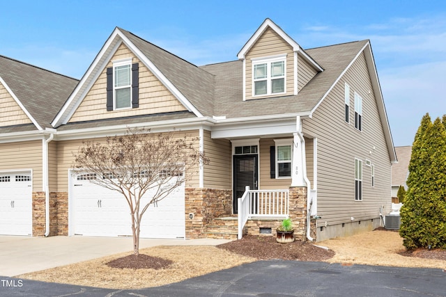 view of front of house with concrete driveway, covered porch, an attached garage, crawl space, and central AC