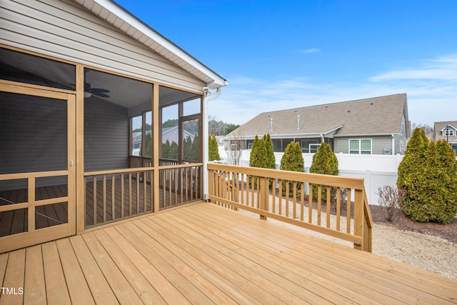 deck with a residential view, fence, ceiling fan, and a sunroom