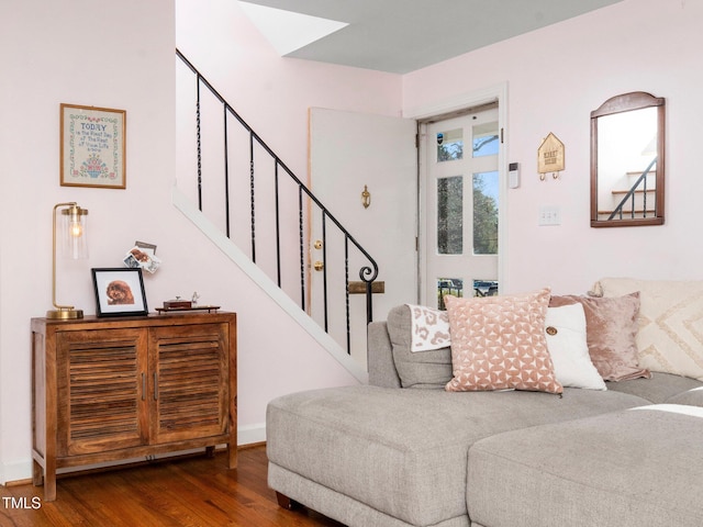 living room featuring dark wood-style floors, baseboards, and stairs