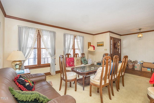 dining area featuring baseboards, ornamental molding, and light colored carpet