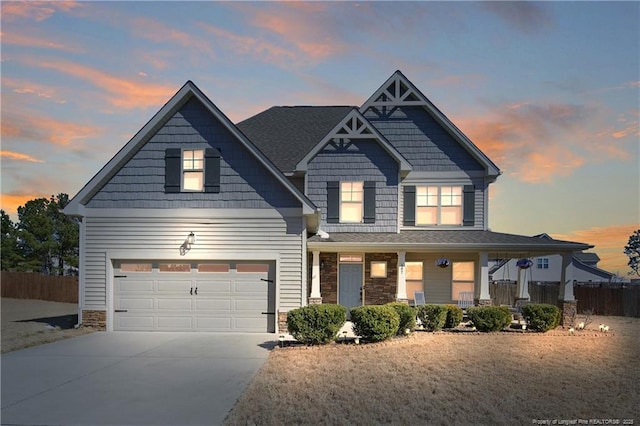 craftsman house with a garage, fence, a porch, and concrete driveway