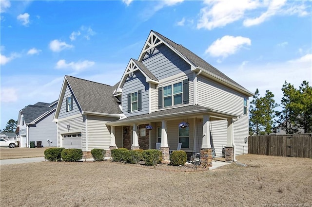 craftsman inspired home featuring an attached garage, covered porch, fence, concrete driveway, and roof with shingles