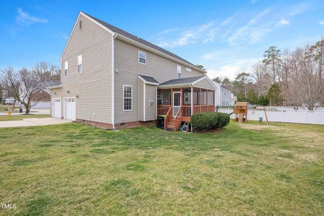 rear view of house featuring fence, driveway, a sunroom, a garage, and crawl space