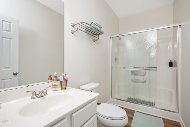 bathroom featuring vanity, a shower stall, toilet, and wood finished floors