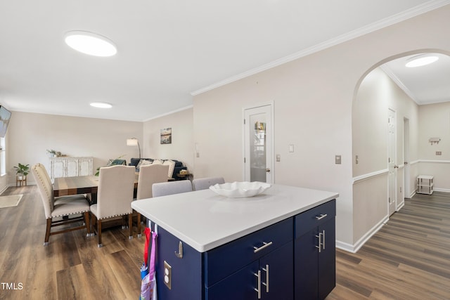 kitchen with a kitchen island, baseboards, dark wood finished floors, arched walkways, and blue cabinets