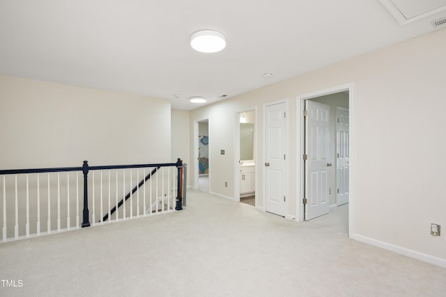 hall featuring an upstairs landing, visible vents, baseboards, and carpet floors