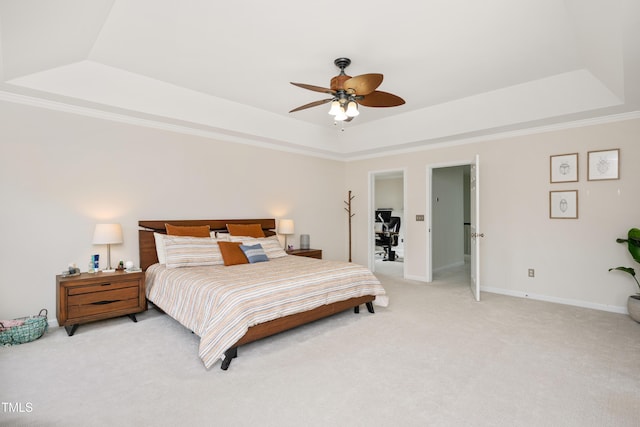 bedroom featuring ceiling fan, a tray ceiling, baseboards, and light carpet