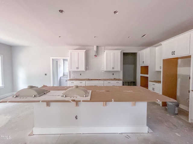 1905 Old Bramble Ln Unit 4, Fuquay Varina, NC 27526 - kitchen featuring a kitchen island, white cabinets, tasteful backsplash, and a breakfast bar area
