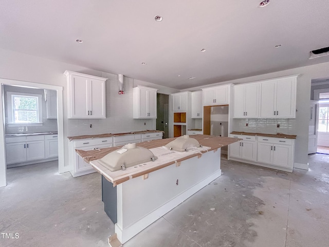 1905 Old Bramble Ln Unit 4, Fuquay Varina, NC 27526 - kitchen with unfinished concrete flooring, a kitchen island, tasteful backsplash, and plenty of natural light