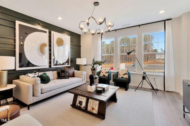 living area featuring recessed lighting, baseboards, light wood finished floors, and an inviting chandelier