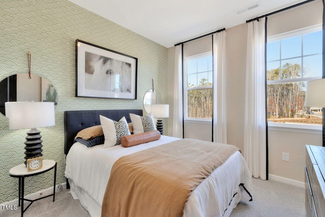 bedroom featuring visible vents, baseboards, light colored carpet, and wallpapered walls