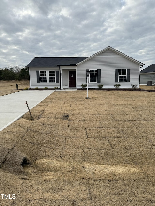 ranch-style house featuring a front yard and cooling unit