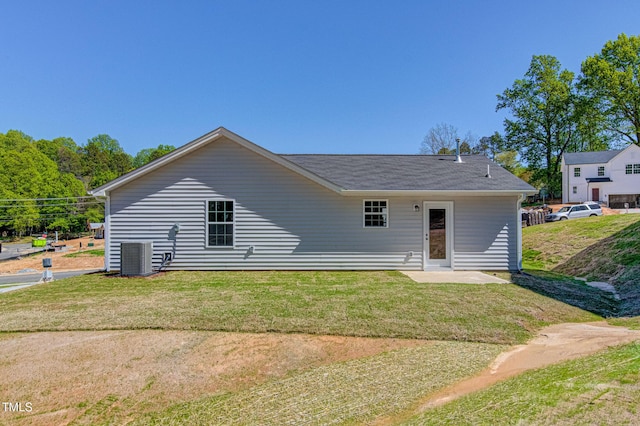 rear view of house featuring central air condition unit, a patio area, and a lawn