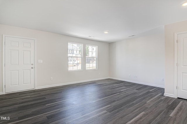 unfurnished room with dark wood finished floors and baseboards