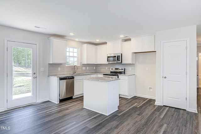 kitchen with white cabinetry, a kitchen island, appliances with stainless steel finishes, and a sink