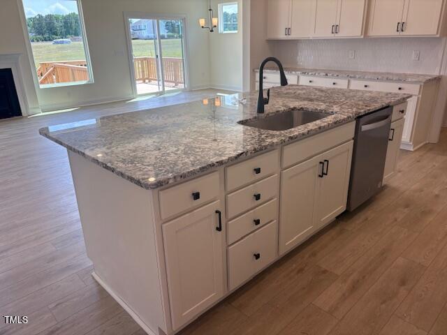 190 Sage Ln Unit 015, Four Oaks, NC 27524 - kitchen with a sink, stainless steel dishwasher, a center island with sink, and light wood finished floors