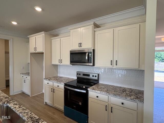 190 Sage Ln Unit 015, Four Oaks, NC 27524 - kitchen with appliances with stainless steel finishes, crown molding, decorative backsplash, light stone countertops, and wood finished floors