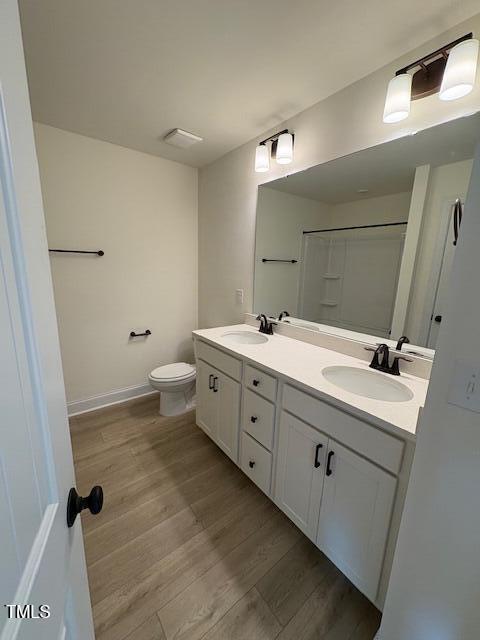 190 Sage Ln Unit 015, Four Oaks, NC 27524 - bathroom featuring wood finished floors, toilet, and double vanity