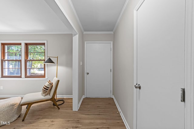 foyer entrance with light wood-style floors, crown molding, and baseboards