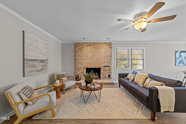 living room with ornamental molding, a fireplace, wood finished floors, and baseboards