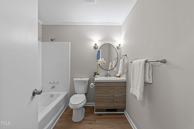 bathroom featuring toilet, ornamental molding, vanity, wood finished floors, and baseboards