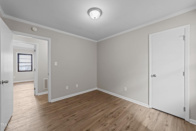 unfurnished room with ornamental molding, visible vents, and wood finished floors