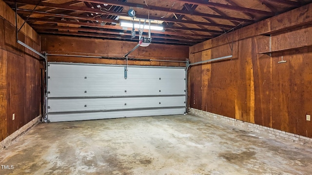 garage featuring wood walls and a garage door opener