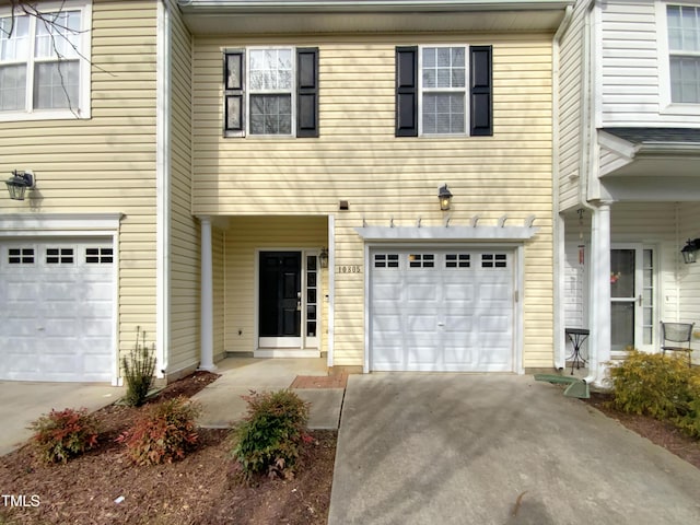 townhome / multi-family property featuring concrete driveway and an attached garage