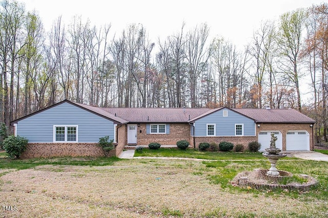 single story home with a garage, a front lawn, concrete driveway, and brick siding