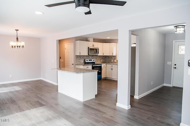 kitchen with range with electric cooktop, stainless steel microwave, light stone countertops, white cabinetry, and backsplash