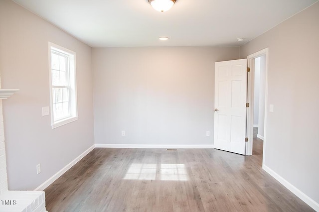 empty room with light wood finished floors and baseboards