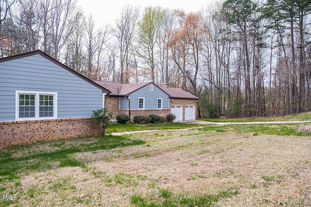 view of front facade featuring a front lawn, brick siding, and an attached garage