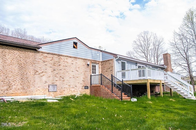 back of house with a yard, stairway, a deck, and brick siding