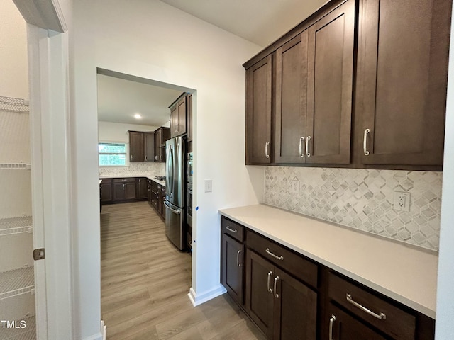 167 S Harvest Ridge Way Unit 223, Wilsons Mills, NC 27520 - kitchen featuring freestanding refrigerator, light wood-type flooring, dark brown cabinets, backsplash, and light countertops