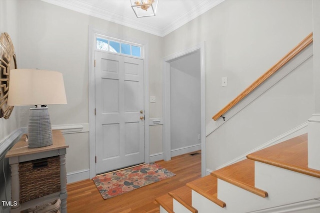 foyer featuring visible vents, baseboards, stairs, crown molding, and light wood-type flooring