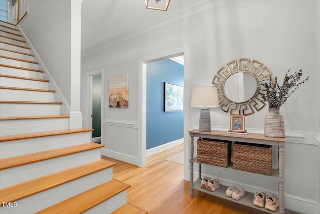 staircase featuring crown molding, baseboards, and wood finished floors