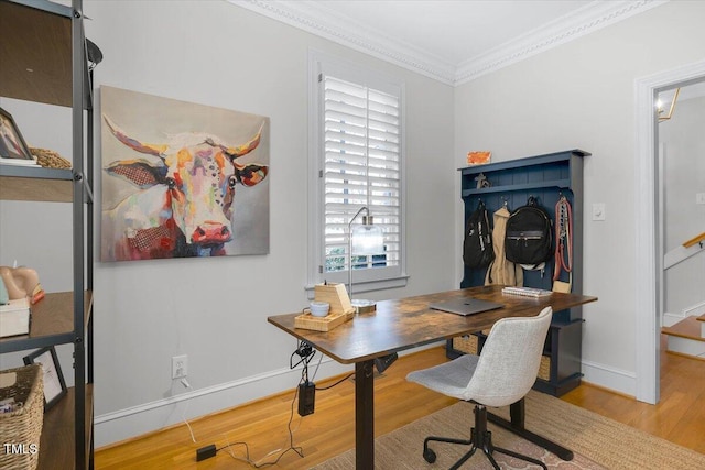 office space with light wood-type flooring, baseboards, and ornamental molding