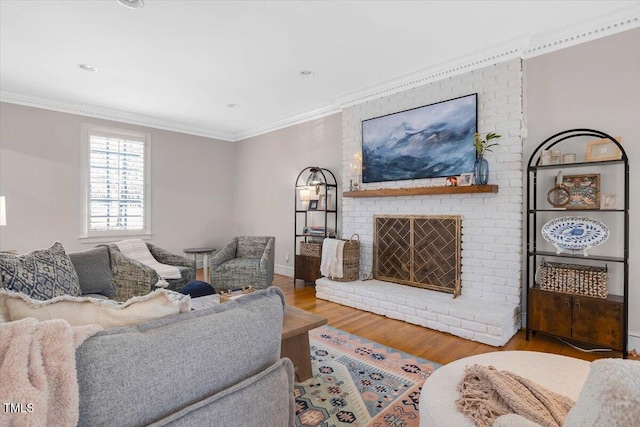 living area with ornamental molding, a brick fireplace, and wood finished floors